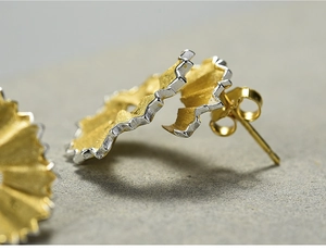 Macro shot of pencil shaving inspired silver stud earring with gold and silver finish