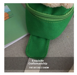 Close-up of green canvas kids bag featuring soft plush trim and durable zipper details