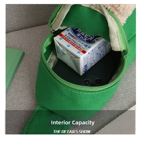 Detail view showing internal capacity of children's green canvas bag with cute plush trim