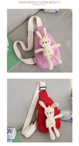 Close-up of pink and red canvas rabbit chest bags for kids on a gray sofa