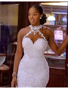 Dettaglio della scollatura in pizzo traforato e della trama sull'abito da sposa a sirena bianco