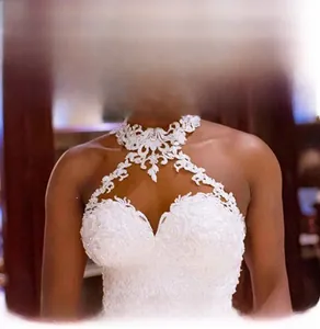 Dettaglio del pizzo floreale sull'abito da sposa bianco con scollo all'americana