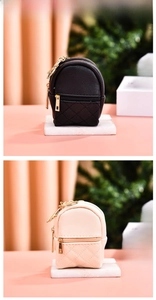 Dettagli di mini zaini in pelle PU neri e beige con cuciture a rombi e cerniera dorata