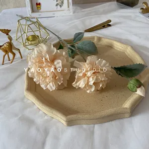 Close-up of 3-head silk peony in champagne color on a decorative octagonal tray