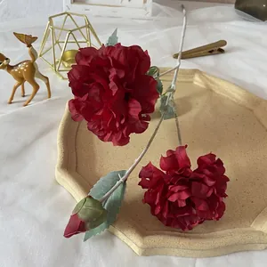 Detail of silk peony petals and buds in dark red with realistic leaf texture on stem