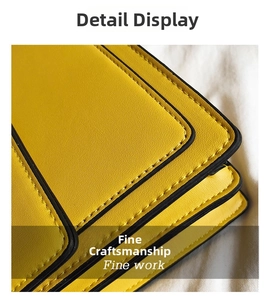 Detail of yellow leather handbag showing precision stitching and black edge paint finish