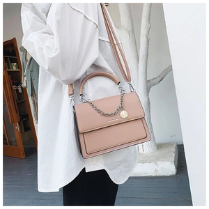 Detail showing the matte PU leather crossbody bag with silver chain and shoulder strap