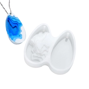 Detail of teardrop resin pendant next to its silicone mold with terrain texture layers