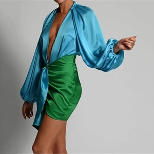 Detail of satin deep V-neck blue top and green pleated mini skirt with draped details