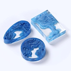 Detailed view of DIY crystal resin pendants in drop and round shapes with ocean wave patterns