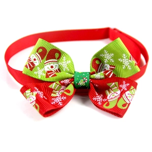 Detail of red and green Christmas pet bow tie with snowman print and adjustable strap