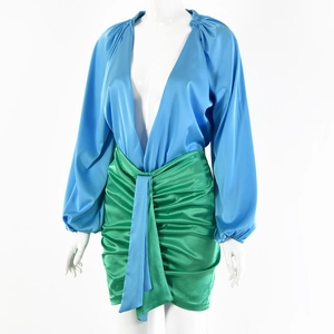Dettaglio di un mini abito in raso bicolore con top blu a V e gonna verde arricciata