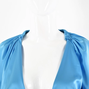 Dettaglio di un body in raso blu con profondo scollo a V e spalle con design a pieghe
