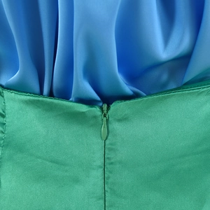 Dettaglio della cerniera invisibile su una gonna di raso verde e parte superiore blu