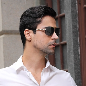 Classic men's square sunglasses with gold metal frame and black lenses in outdoor setting