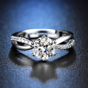 Close-up of a sparkling round-cut faux diamond ring with twisted band on dark background