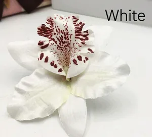 Detail of a white artificial orchid hair clip with realistic brownish-red spots and texture