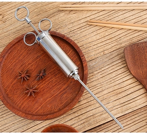 Détail d'un injecteur de marinade en acier inoxydable 304 sur une table pour BBQ