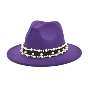 Detailed view of dark purple wool fedora with black ribbon and elegant pearl embellishments