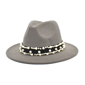 Detail of gray wool fedora hat featuring black ribbon band with elegant pearl embellishments