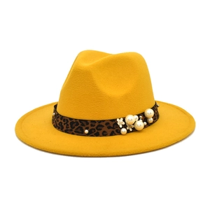 Detail of mustard yellow wool fedora hat with leopard ribbon and pearl accents
