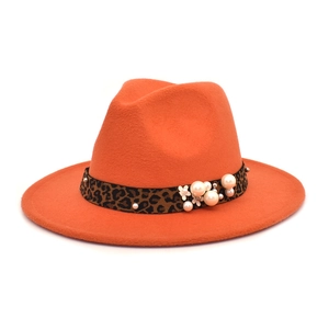 Detail of orange wool fedora with leopard print band, pearls, and flower embellishments
