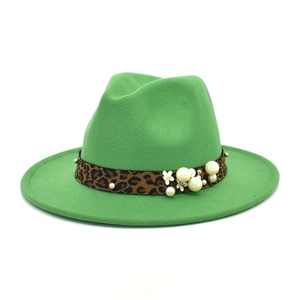 Detail of green wool fedora hat featuring leopard print band with white pearls and flower