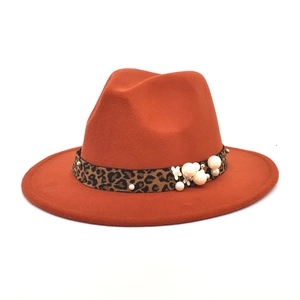 Detail of caramel fedora hat with leopard band, white pearls and floral accents