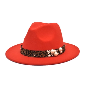 Detail view of red wool fedora featuring leopard print band with pearls and floral accent