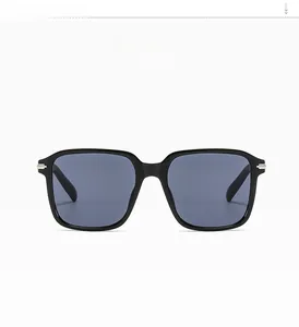 Detail view of shiny black square frame sunglasses with dark smoke lenses and metal accents