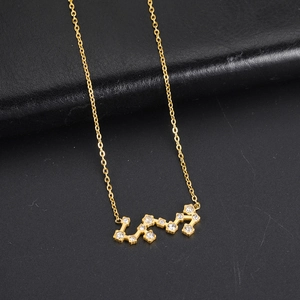 Détail d'un collier pendentif zodiaque doré orné de zircons blancs étincelants