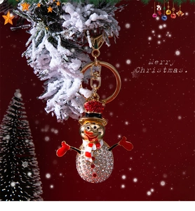 Close-up of a sparkling Christmas snowman keychain with red hat and crystals