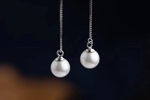 Detail view of S925 silver threader earrings featuring round white pearls on box chains