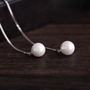 Close-up of elegant s925 silver thread earrings with lustrous white round pearls