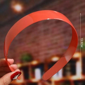 Detail of bright orange plastic headband with inner non-slip teeth, 13.5cm height