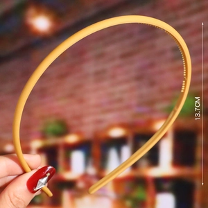 Detail shot of a yellow wavy plastic headband showing the 13.7cm height measurement