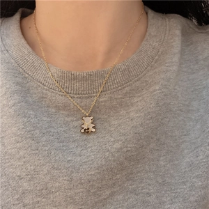 Close-up of golden bear pendant with white shell inlay and Love engraving detail
