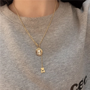 Golden bear necklace featuring mother of pearl pendant with mixed link chain on model