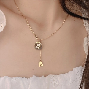 Detail of gold asymmetric bead chain with white mother-of-pearl bear pendant