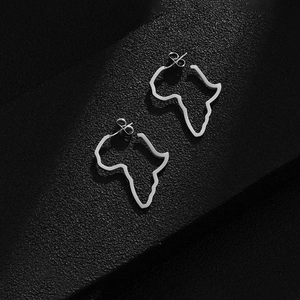 Detailed view of silver Africa map stud earrings on a textured black leather surface