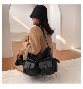 Model showcasing a black large-capacity tote bag with dual front flap pockets