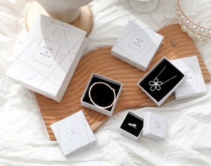 Detail of marble pattern jewelry gift box and paper bag set with gold lettering