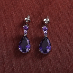 Macro detail of silver drop earrings featuring purple pear-cut and round cubic zirconia