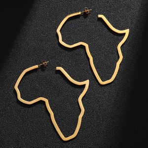 Detail of gold polished Africa map hollow hoop earrings on a black textured surface