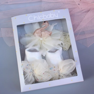 Gift box with baby swan headband and white knit socks featuring large mesh bows