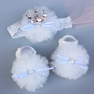 Detailed view of white baby headband and socks set with lace flower and silver crown