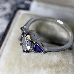 Vintage silver ring featuring clear marquise zircon and blue side stones on a box