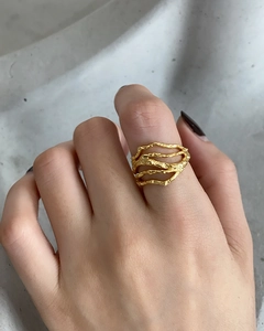 Irregular textured gold plated 925 silver ring worn on index finger with lava pattern