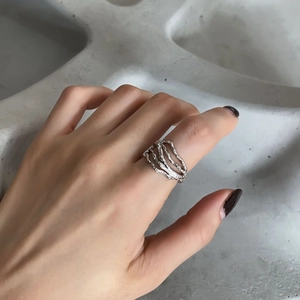 Macro shot of 925 sterling silver ring with liquid lava texture and open-loop design