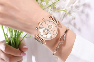 Rose gold watch and teardrop bracelet set worn on wrist with floral background